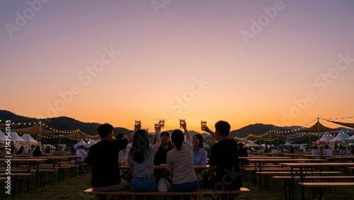 Food Festival - Group of young Korean friends toasting drinks at outdoor evening event