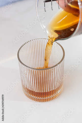 Foto Coffee stream pouring into a transparent glass with rich brown tones, ideal for beverage and cafe concepts