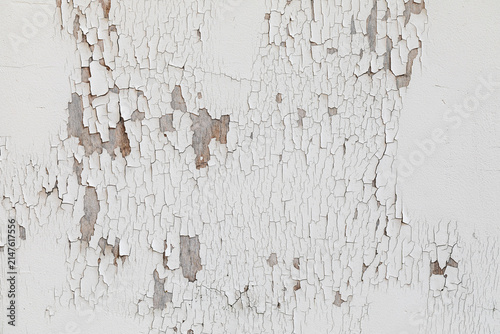 Old white cracked paint peeling off to reveal wood surface