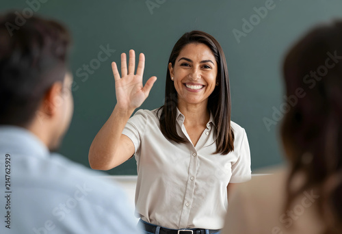 Smiling female teacher wavi...