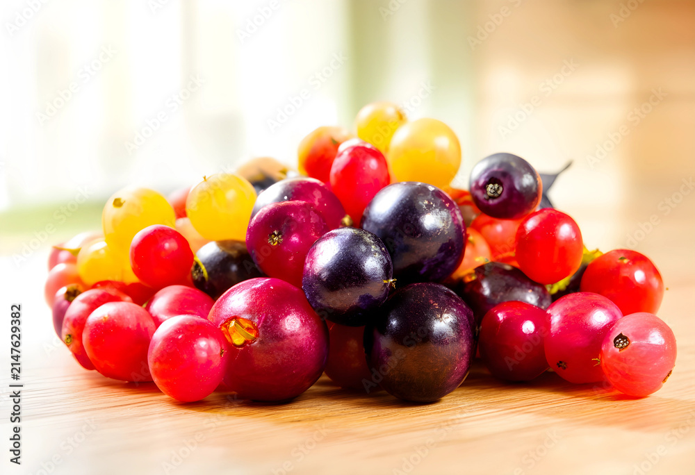 Obraz premium Pile of fresh colorful grapes on a wooden surface, healthy eating and natural food
