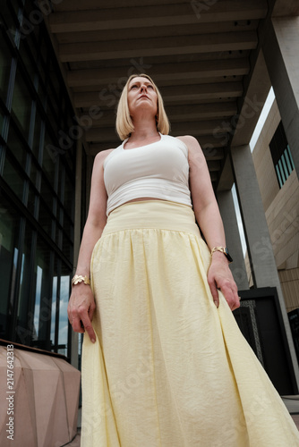 Photography Confident blonde woman looking up in urban setting