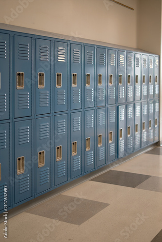 Row of blue metal lockers in a school hallway interior