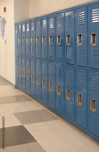 Long row of blue metal school lockers in a school hallway