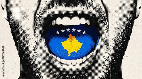 A gritty, black and white close-up of an open mouth with the vibrant blue and yellow flag of Kosovo on the tongue, symbolizing national identity or expression.