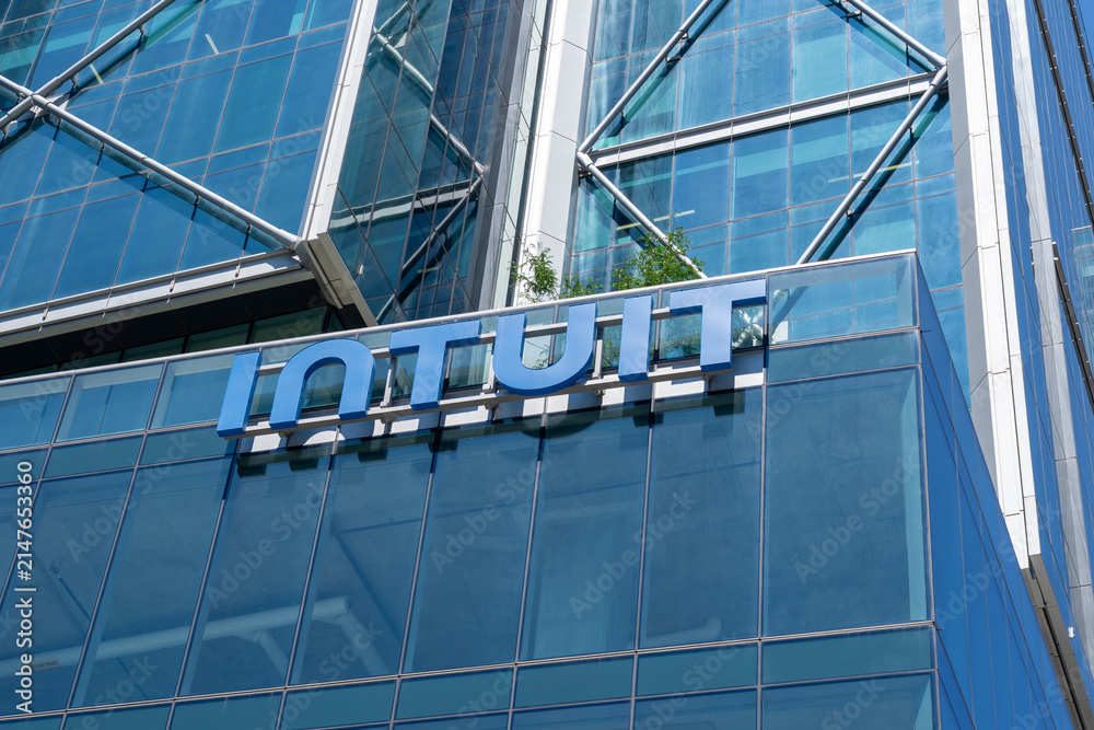 Fototapeta premium Toronto, Ontario, Canada - August 5, 2026: Close up of Intuit logo sign on the building at their Canadian Headquarters at The Well on Spadina Ave in downtown Toronto, Canada. Intuit Inc is an America