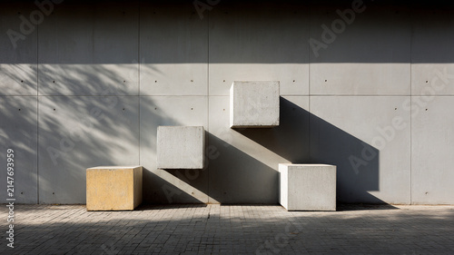 Gray wall, concrete cube, geometric shadow, minimalist abstract, sunlight pattern on urban pavement with clean modern exterior facade