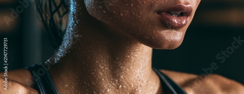 Young athletic woman with sweat after workout in gym, close-up photo 