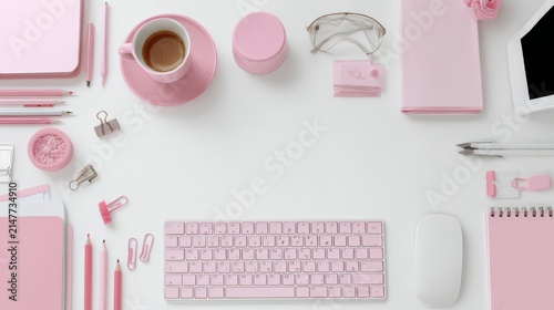 Top view of a modern business workspace with computer keyboard, mouse, cup of coffee, stationery, pens, clips, pink adhesive tape, and planners arranged on an isolated white background with clean copy