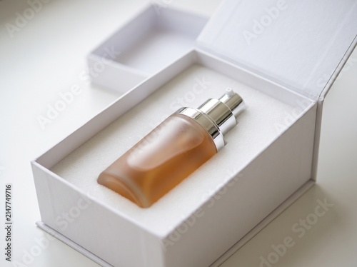 Elegant Skincare Bottle with Silver Cap Placed Inside a Minimalist White Gift Box for Beauty Packaging and Cosmetics Presentation