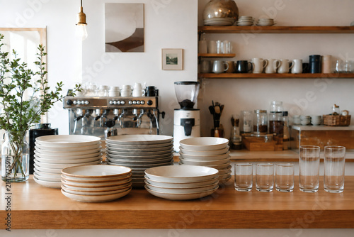 Cozy Scandinavian Cafe Counter with Stacked Ceramic Plates and Glassware in Warm Natural Light
