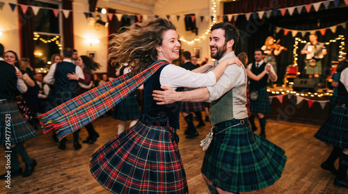 Happy couple dancing at a traditional Scottish Hogmanay ceilidh celebration
