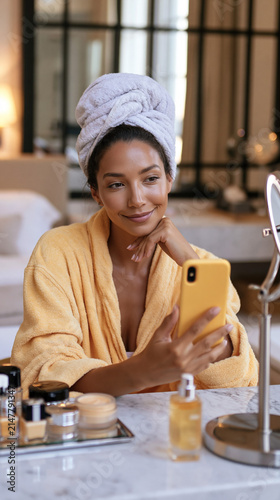 Woman taking a selfie in a hotel room while getting ready in the morning