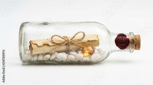 Message in a bottle with a scroll, a gemstone, and white stones isolated on white background
