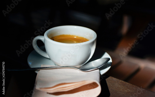 Hot coffee in a mug, and the shadows of the morning light.