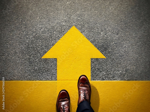 Brown Leather Dress Shoes Facing Yellow Directional Arrow Symbolizing Career Growth, Decision Making, Success, Leadership, and Future Opportunities Ahead.