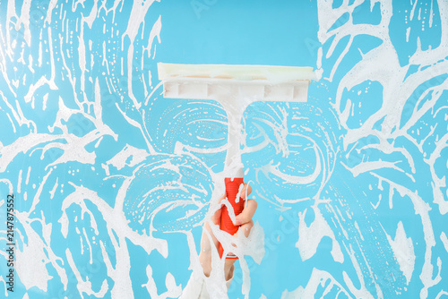 Female hand with squeegee a...