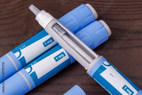 Canvastavla Semaglutide GLP-1 medication pen injector resting on a dark wooden table top, su