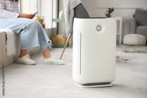 Woman adjusting air purifie...