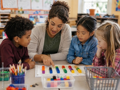 Female Teacher Guiding Diverse Group of Elementary Students in a Math Activity Using Colorful Counting Blocks in a Bright Classroom Setting