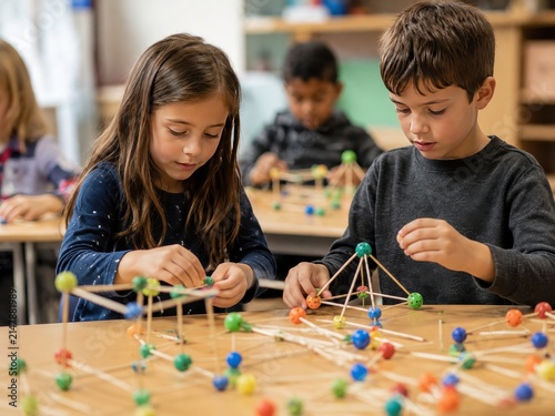 Focused Young Children Building Geometric Structures with Wooden Sticks and Colorful Clay Connectors in a Bright Classroom STEM Learning Activity