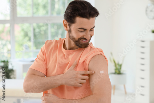Young man with applied medical patch after vaccination in clinic