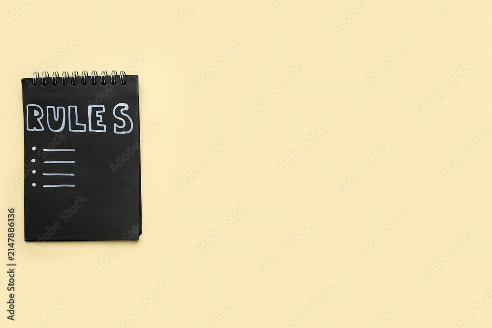 Fototapeta premium Notebook with blank list of rules on beige background