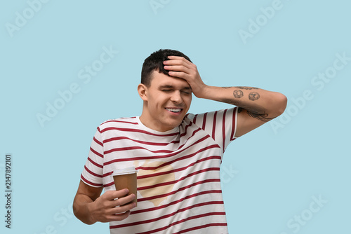 Smiling young man with stains on his striped t-shirt on blue background