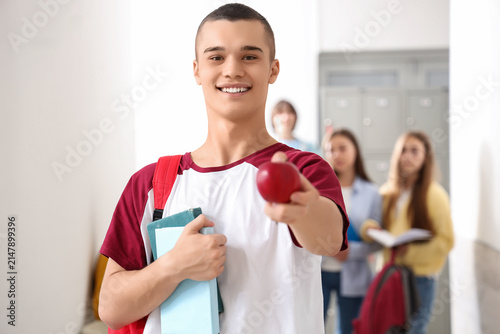 Teenage boy with books at school