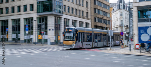 Modern Brussels tram moving along historic streets with panning effect, traditional European architecture and urban public transportation in the Belgian capital.