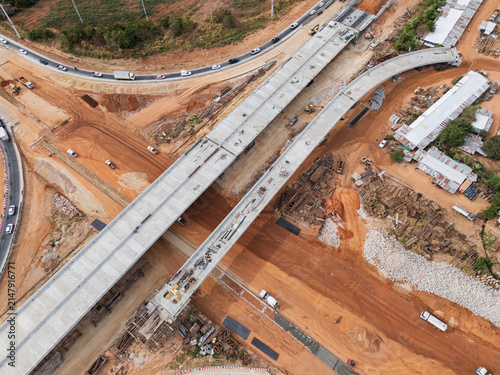The construction site before the construction of the concrete bridge over the intersection by crane workers, tractors, and backhoes
