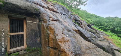 Exterior View of Ancient Rock Cut Facade and Wet Basalt Walls of Kuda Caves in Monsoon, Maharashtra