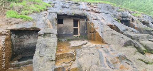 Exterior View of Ancient Rock Cut Facade and Wet Basalt Walls of Kuda Caves in Monsoon, Maharashtra