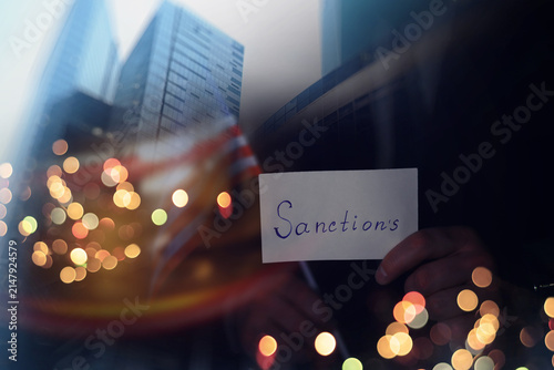 Obraz na plátne Man showing sanctions word on paper and devastated middle aged caucasian man in