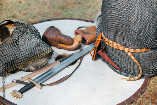 Fotografie Various pieces of medieval armor are placed on a wooden surface