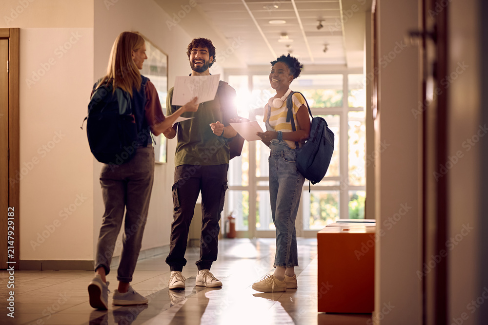 Fototapeta premium Happy college friends with test results in hallway.