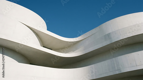 Modern Architecture: A striking white building with flowing curves stands against a vibrant blue sky, showcasing contemporary design and sleek aesthetics.