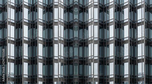 Symmetrical Skyscraper Facade: A modern skyscraper's facade creates a mesmerizing symmetrical pattern, showcasing a repeating motif of glass windows and geometric architectural elements.