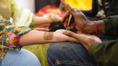 Applying Intricate Henna Design on Hand for Traditional Celebration