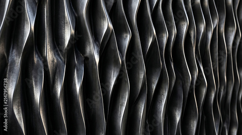 Abstract Metal Ribs Texture: A close-up view of a repeating pattern of dark, undulating metal ribs, creating a sense of depth and industrial art.