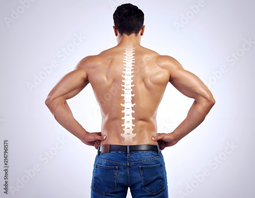 Muscular man's back with a spinal column overlay, hands on hips, neutral background
