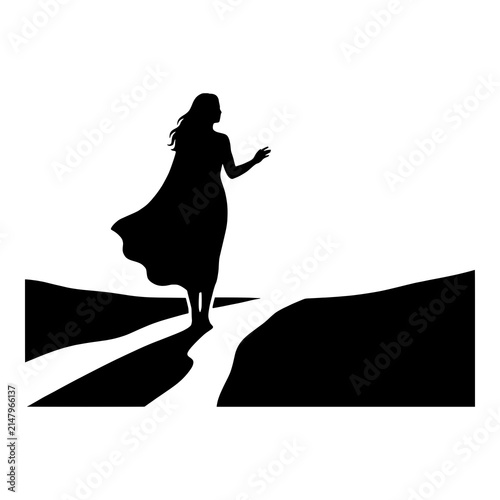 Silhouette of woman with flowing cape walking towards mountain light.