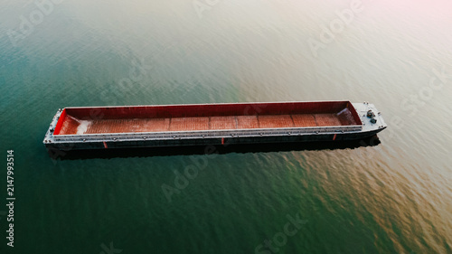 Obraz na plátne An empty river transport barge on the Danube River during a sunset