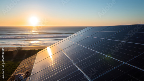 Solar Panels Reflecting Golden Sunset Over Ocean Horizon, Sustainable Energy Concept