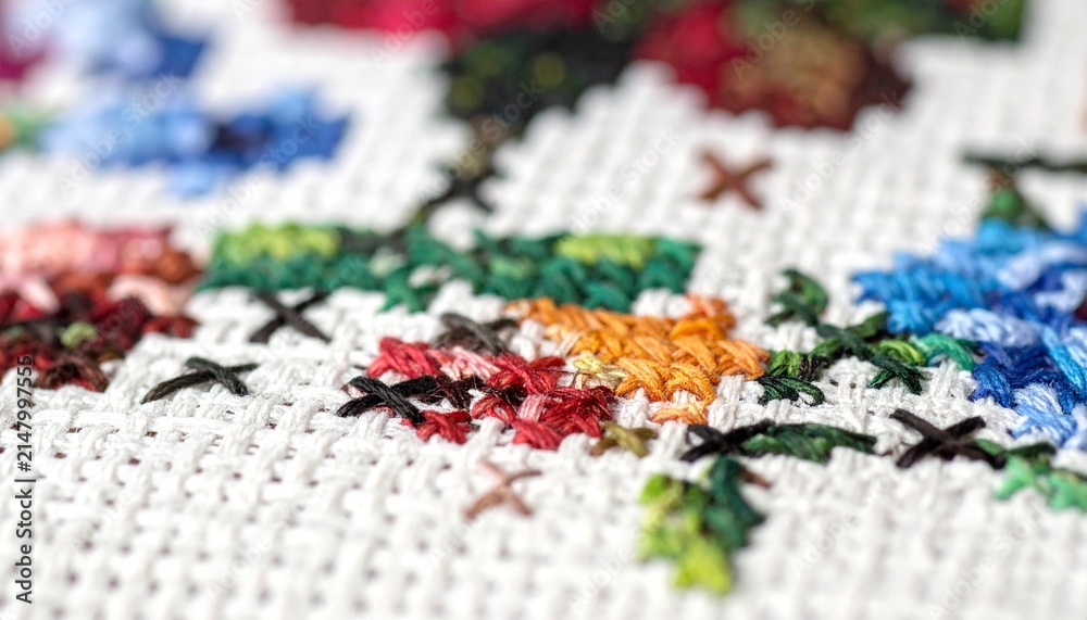 Obraz premium Close-up macro view of colorful cross-stitch embroidery, detailed texture of