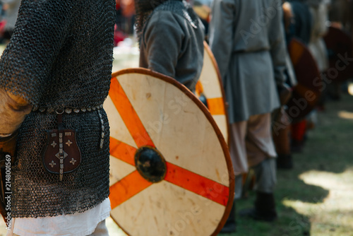 Canvas Print A group of medieval reenactors stands in formation, dressed in chainmail and tun