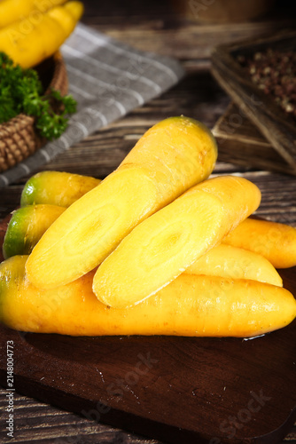 Fresh Yellow Xinjiang Carrots on Wooden Cutting Board - Seasonal Farm Vegetables