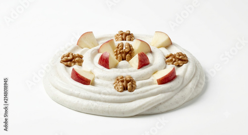 Distant shot of 5 to 10 red apple wedges and walnuts naturally resting on thick white honey cinnamon cream