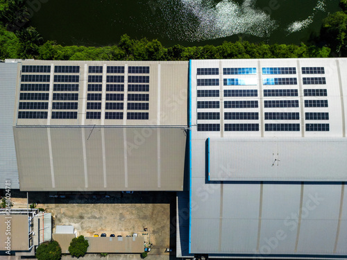 Fotografie Overhead drone frame of a solar array spanning two neighbouring warehouse roofs by a canal in an industrial estate, a clean energy asset cutting carbon emissions