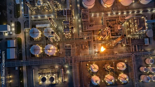 Aerial Night View of Oil and Gas Refinery Plant with Illuminated Pipelines and Storage Tanks
